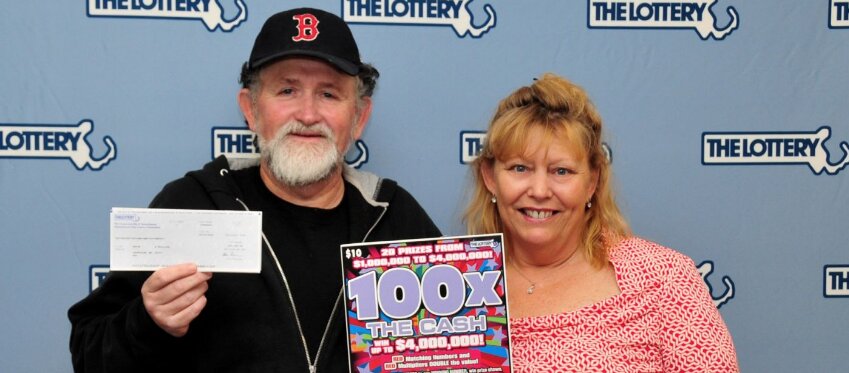 La pareja de agraciados posa con el cheque millonario. Foto: Lotería de Massachusetts.